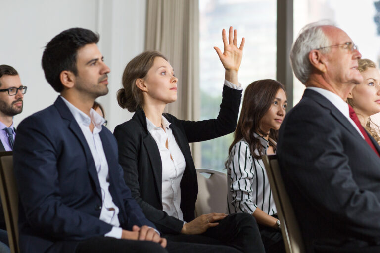 woman raising her hand amidst the discussion